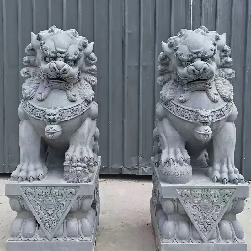 Gray stone Foo Dog statues in a male and female pair with carved pedestals
