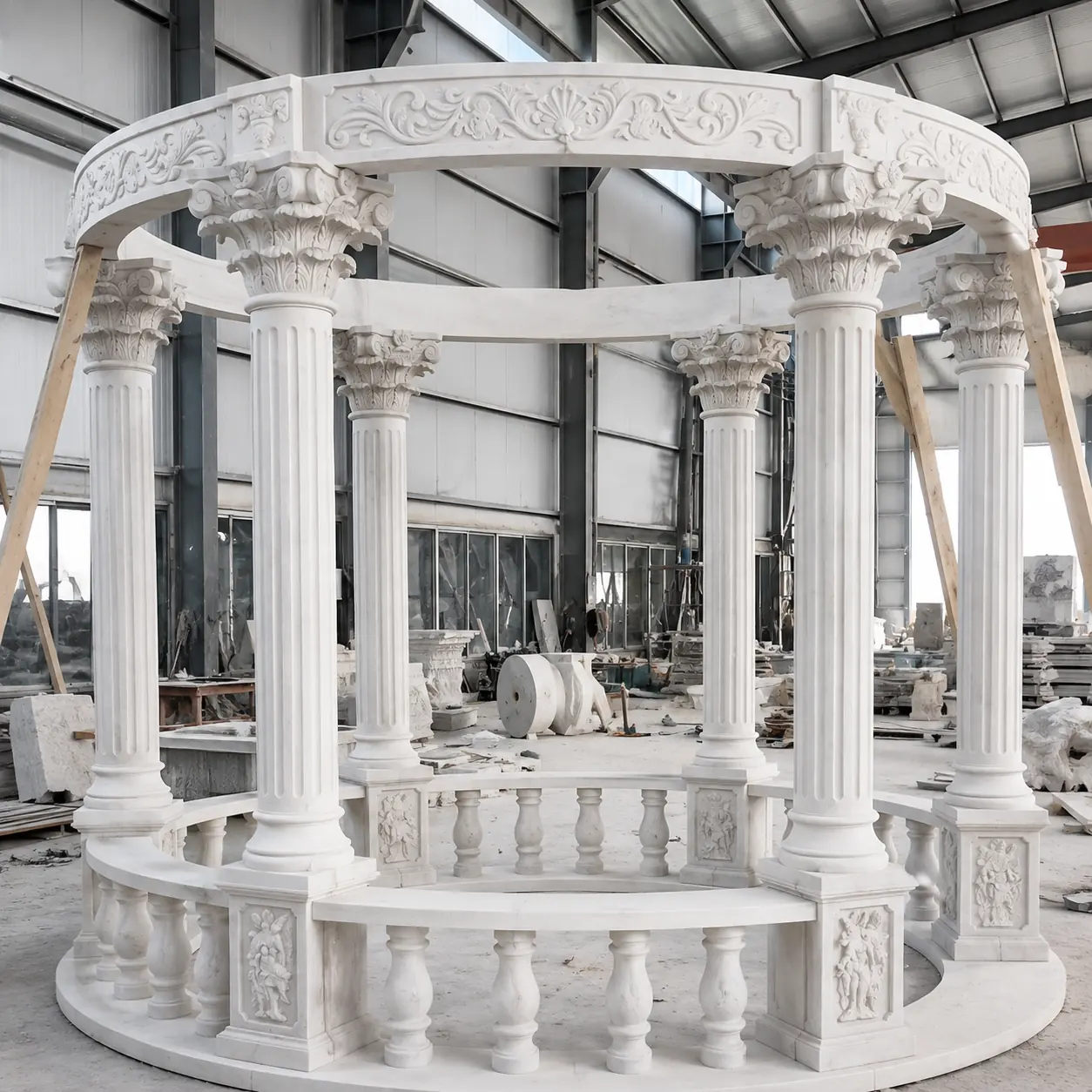Round white marble gazebo with carved balustrade and classical columns during factory assembly