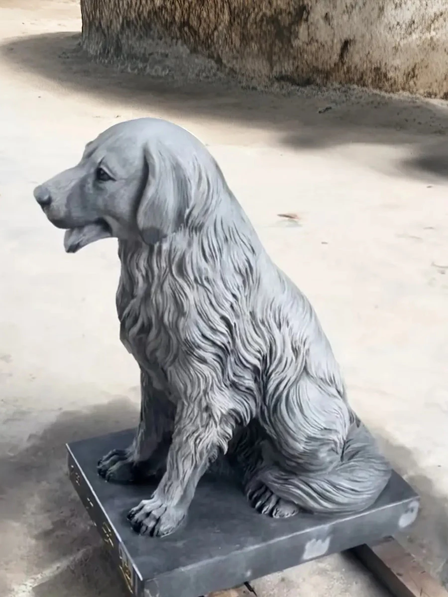 Seated long-haired marble dog sculpture with carved coat detail and a rectangular stone base, photographed at the workshop.